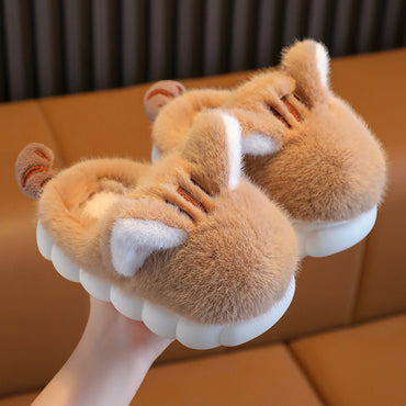 Pair of fluffy slippers with animal ears and paws on a brown surface.